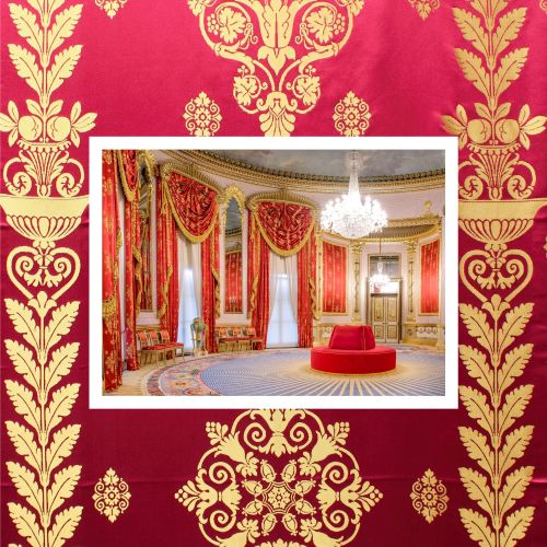 A richly decorated, circular palace room with red and gold damask walls and matching draped curtains. Ornate gilded mouldings frame tall windows, and a large crystal chandelier hangs from the ceiling. In the centre sits a round red upholstered seat on a patterned carpet. The image is bordered by a close-up of the same red-and-gold damask fabric, creating a layered, decorative frame.