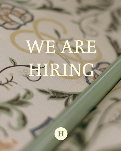 Cream fabric with a gold and green swirly floral pattern and writing overlay that reads WE ARE HIRING