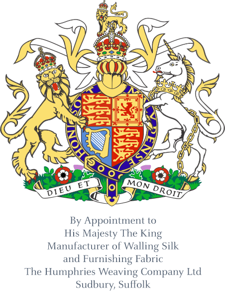 Ornate royal coat of arms featuring a crowned shield supported by a lion on the left and a chained unicorn on the right, both wearing crowns. The shield is divided into sections with heraldic symbols in red, blue, and gold. Above is a crowned helmet with decorative flourishes. Below, a banner reads “Dieu et mon droit.” Under the emblem is text: “By Appointment to His Majesty The King, The Humphries Weaving Company Ltd., Manufacturer of Walling Silk and Furnishing Fabrics, Sudbury, Suffolk.